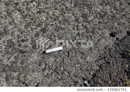 Cigarette butts left on the ground. Copy space available. 139862761