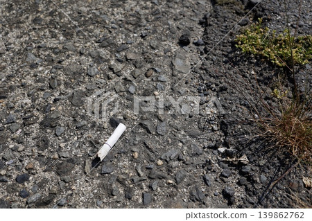 Cigarette butts left on the ground. Copy space available. 139862762