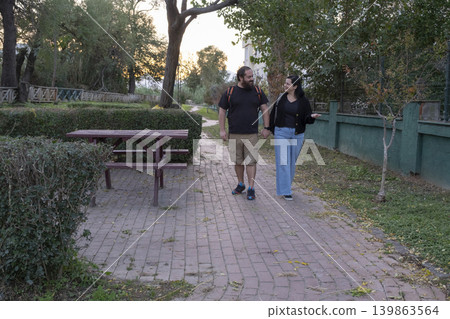 Couple Holding Hands Walking in Park. Couple Holding Hands Walking in Park. 139863564