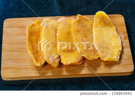 Kitchen table with dried mango on board Kitchen table with dried mango on board 139863943