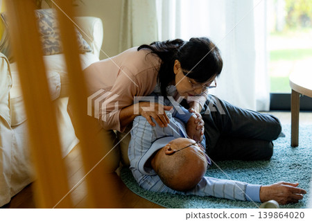 A senior man who has collapsed and a senior woman providing first aid. A senior man who has collapsed and a senior woman providing first aid. 139864020