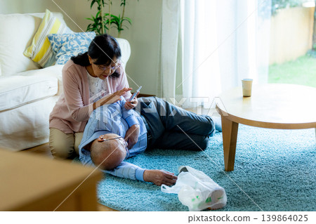 A senior man who has collapsed and a senior woman providing first aid. A senior man who has collapsed and a senior woman providing first aid. 139864025