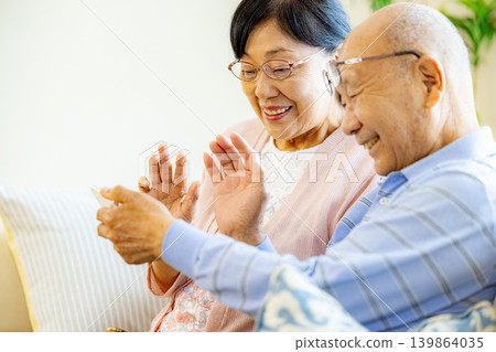 Senior couple making a video call on their smartphone Senior couple making a video call on their smartphone 139864035