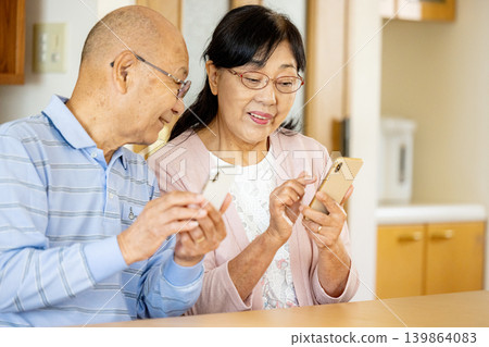 Senior couple watching a smartphone Senior couple watching a smartphone 139864083