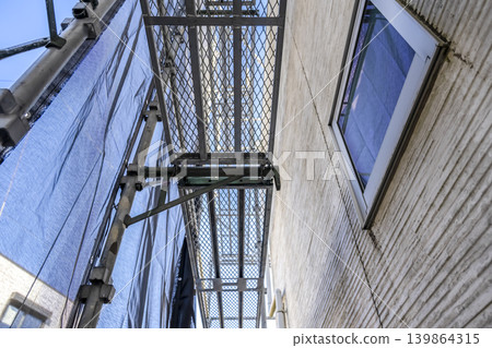 Exterior wall of a house with windows and temporary scaffolding immediately after construction began. 139864315