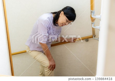 Senior woman climbing stairs 139864418