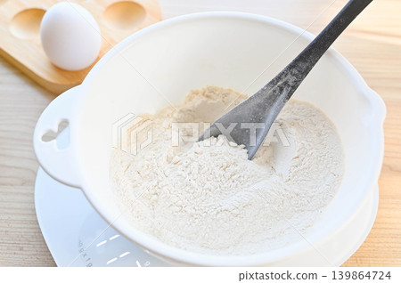 Measure the flour and other ingredients in a bowl. Measure the flour and other ingredients in a bowl. 139864724