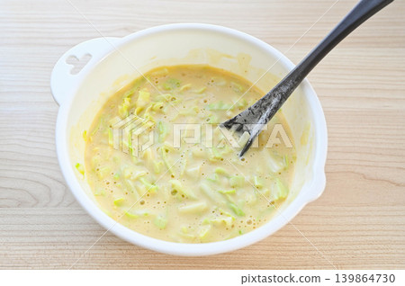 在大阪燒麵糊中加入高麗菜。 在大阪燒麵糊中加入高麗菜。 139864730