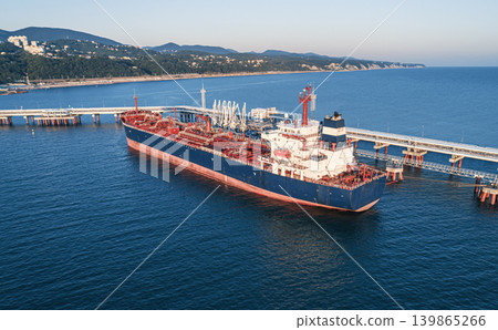 Aerial view of a large oil tanker docked at a pier in the port in process of loading. Aerial view of a large oil tanker docked at a pier in the port in process of loading. 139865266