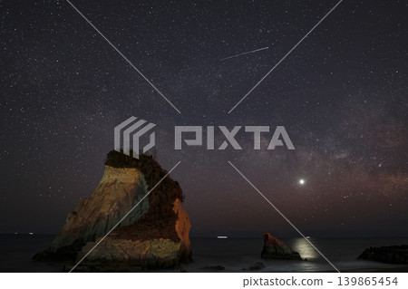 繁星點點的夜空,銀河和流星劃過,映襯著海岸邊奇形怪狀的岩石地形。 繁星點點的夜空,銀河和流星劃過,映襯著海岸邊奇形怪狀的岩石地形。 139865454