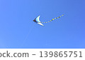 Blue Kite Soaring Across Clear Summer Sky 139865751