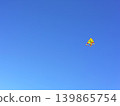 Bright Yellow Kite Against Clear Blue Sky 139865754