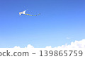 White Kite Flying Across the Blue Sky 139865759