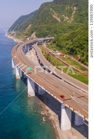 The Hokuriku Expressway winds its way along the cliffs of Oyashirazu Coast (vertical orientation, drone aerial photography) The Hokuriku Expressway winds its way along the cliffs of Oyashirazu Coast (vertical orientation, drone aerial photography) 139865980