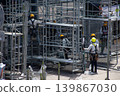 Workers working on scaffolding at a construction site 139867030