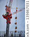 Tower crane at a high-rise construction site lifting materials. 139867031