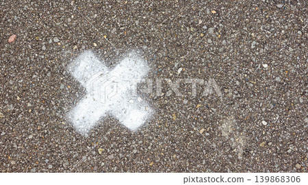 An image of an "X" mark drawn on asphalt. 139868306