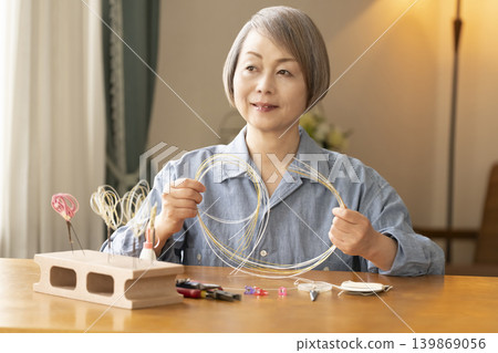 Senior woman making hair ornaments with mizuhiki (decorative cord) Senior woman making hair ornaments with mizuhiki (decorative cord) 139869056