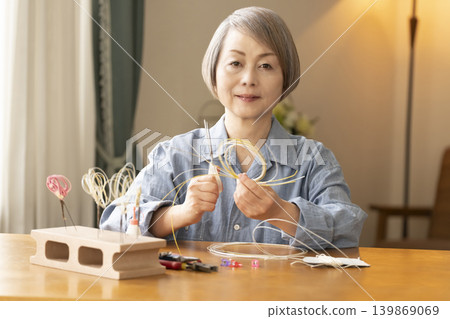一位老年婦女用水引繩製作髮飾 一位老年婦女用水引繩製作髮飾 139869069