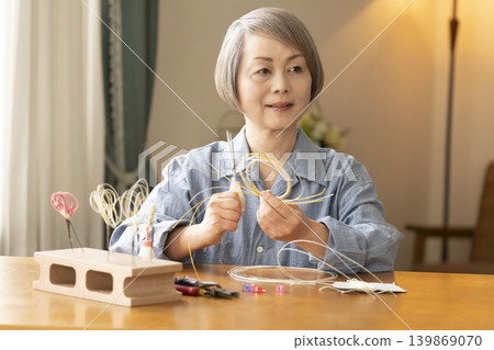 一位老年婦女用水引繩製作髮飾 一位老年婦女用水引繩製作髮飾 139869070