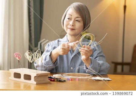 一位老年婦女用水引繩製作髮飾 一位老年婦女用水引繩製作髮飾 139869072