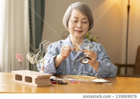 一位老年婦女用水引繩製作髮飾 一位老年婦女用水引繩製作髮飾 139869079