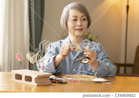 一位老年婦女用水引繩製作髮飾 一位老年婦女用水引繩製作髮飾 139869082