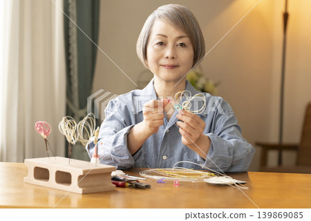 Senior woman making hair ornaments with mizuhiki (decorative cord) Senior woman making hair ornaments with mizuhiki (decorative cord) 139869085