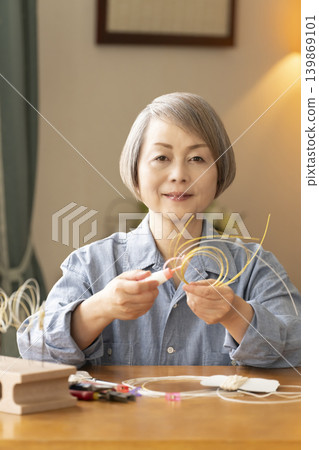 Senior woman making hair ornaments with mizuhiki (decorative cord) 139869101