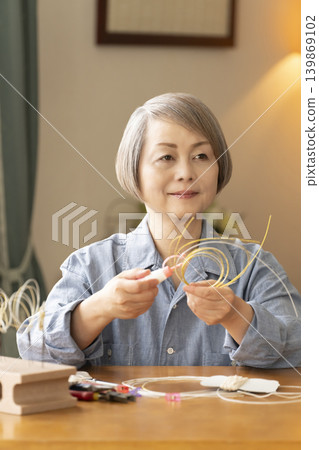 一位老年婦女用水引繩製作髮飾 一位老年婦女用水引繩製作髮飾 139869102