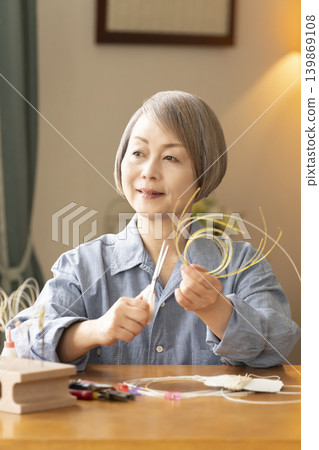 一位老年婦女用水引繩製作髮飾 139869108