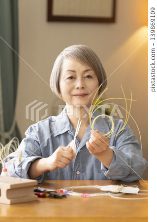 一位老年婦女用水引繩製作髮飾 139869109