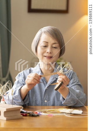 一位老年婦女用水引繩製作髮飾 139869111