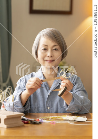 Senior woman making hair ornaments with mizuhiki (decorative cord) Senior woman making hair ornaments with mizuhiki (decorative cord) 139869113