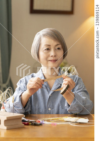 一位老年婦女用水引繩製作髮飾 139869114