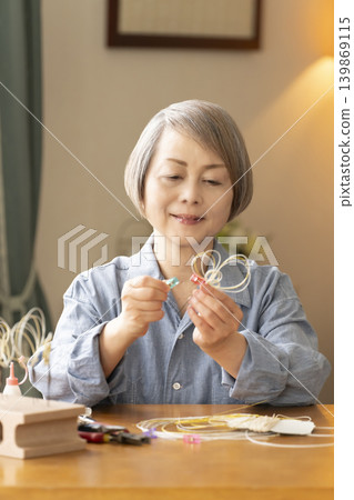 一位老年婦女用水引繩製作髮飾 139869115