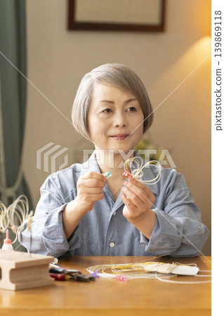 一位老年婦女用水引繩製作髮飾 139869118