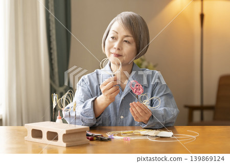 一位老年婦女用水引繩製作髮飾 139869124