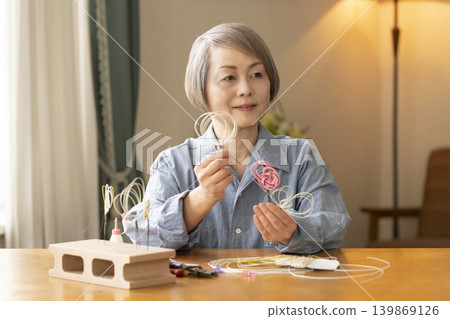 一位老年婦女用水引繩製作髮飾 139869126