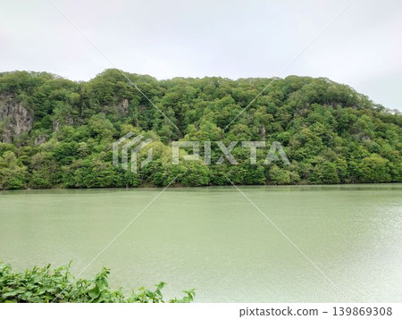 The scenery of lush green mountains and a tranquil lake. The scenery of lush green mountains and a tranquil lake. 139869308