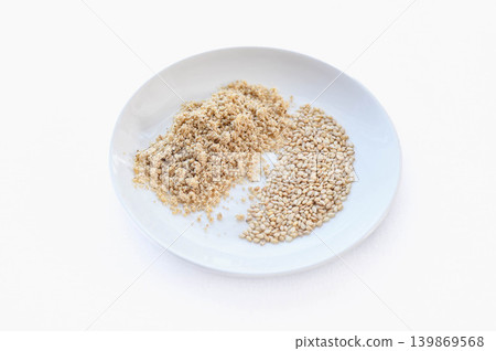 烤芝麻和芝麻粉盛裝在白色盤子裡。 烤芝麻和芝麻粉盛裝在白色盤子裡。 139869568