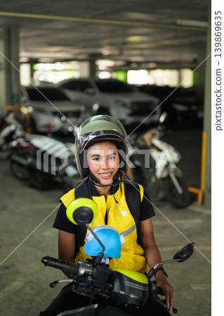 Vertical Portrait of Smiling Thai Female Delivery Driver on Scooter Vertical Portrait of Smiling Thai Female Delivery Driver on Scooter 139869635