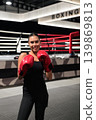 Smiling Female Boxer in Red Gloves by Ring 139869813