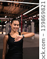 Smiling Female Athlete Checking Smartwatch in Vertical Shot 139869821
