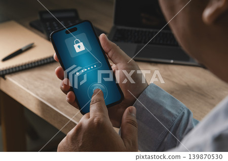 Person using smartphone with password and fingerprint authentication interface in office workspace, suitable for banking security, payment protection, account recovery, and digital privacy concepts. Person using smartphone with password and fingerprint authentication interface in office workspace, suitable for banking security, payment protection, account recovery, and digital privacy concepts. 139870530