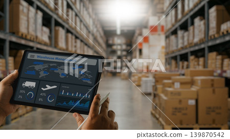 Warehouse staff using tablet dashboard for inventory tracking, shipping analysis, logistics monitoring and supply management inside modern storage and distribution warehouse facility. Warehouse staff using tablet dashboard for inventory tracking, shipping analysis, logistics monitoring and supply management inside modern storage and distribution warehouse facility. 139870542