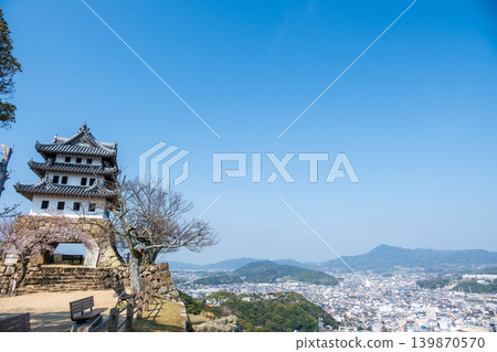 A view of the castle tower of Sumoto Castle ruins and the city of Sumoto (Awaji Island) with cherry blossoms in bloom. A view of the castle tower of Sumoto Castle ruins and the city of Sumoto (Awaji Island) with cherry blossoms in bloom. 139870570