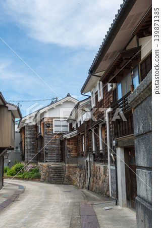 位於富山縣南東市城花町的迷人小巷，兩側是石牆和木製建築。 139871385