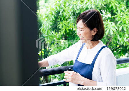 A woman cleaning the balcony A woman cleaning the balcony 139872012