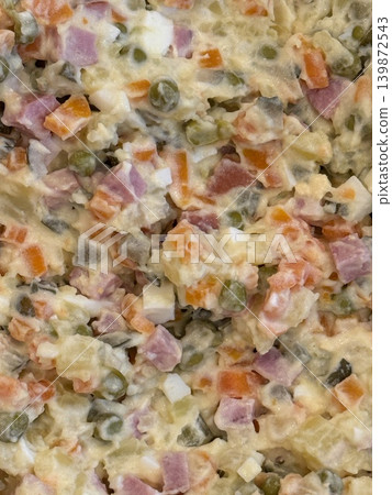 Olivier salad with diced vegetables and meat in a creamy dressing, ideal for background or recipe Olivier salad with diced vegetables and meat in a creamy dressing, ideal for background or recipe 139872543